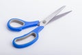 A half open pair of scissors with a blue grip