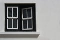 A half-open wooden and glass window in a white exterior wall Royalty Free Stock Photo