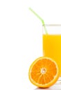 Half orange in front of glass of orange juice with straw on white background Royalty Free Stock Photo