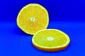 Half an orange and a slice in a section on a dark blue background. Healthly food.