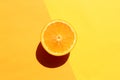 Half of orange on yellow background. Citrus fruit slice on colored backdrop. Top view, copy space. Summer tropical background. Royalty Free Stock Photo