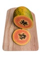 Half papaya with slice on wooden cutting board isolated on white background Royalty Free Stock Photo