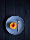 Half peach and fork on the plate