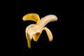 Half peeled ripe banana on black background Royalty Free Stock Photo