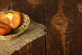 Half persimmon in wicker basket on Mat, on wooden surface