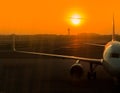 Half plane closeup Parked in a runway on the airport runway to pick up passengers during the evenings and with warm orange lights