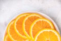 Half a plate with round slices of juicy orange on the table close up Royalty Free Stock Photo