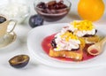 Half the plums next to a plate with toasted French bread. Royalty Free Stock Photo