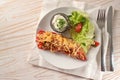 Half pointed bell pepper baked with rice  tuna  tomatoes and cheese on a white plate with lettuce salad and dip on white painted Royalty Free Stock Photo