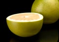 Half of pomelo, chinese grapefruit isolated on black