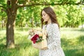 Half portrait of a charming positive woman dressed in long white summer dresses with a happy smile on the background of a green Royalty Free Stock Photo