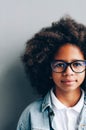 Half a portrait of a dark-skinned girl near a gray wall Royalty Free Stock Photo