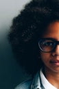 Half a portrait of a dark-skinned girl near a gray wall Royalty Free Stock Photo