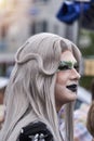 Half portrait of drag queen with gray hair and heavily made up face at CSD parade