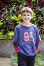 Portrait of happy eight year old birthday boy wearing number 8 shirt