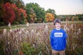 Half portrait of a smiling nine year old boy outside in Autumn with colorful fall trees Royalty Free Stock Photo