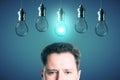 Half portrait of young european businessman with abstract glowing row of light bulbs on red background. Idea, solution and Royalty Free Stock Photo