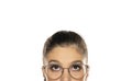 Half portrait of young puzzled woman with glasses, looking up