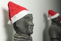 Half profile of Chinese terracotta warrior statue wearing santa hat