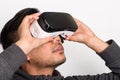 Half profile of young asian man holding virtual reality goggles