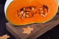 Half of a pumpkin with orange flesh on a wooden board Royalty Free Stock Photo