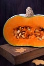 Half of a pumpkin with orange flesh on a wooden board Royalty Free Stock Photo