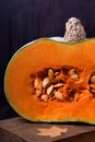 Half of a pumpkin with orange flesh on a wooden board Royalty Free Stock Photo