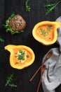 Half pumpkin with soup on black background. Flat lay. Vertical composition. Greens and veggies Royalty Free Stock Photo