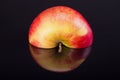 Half of red apple with reflection isolated on black background Royalty Free Stock Photo