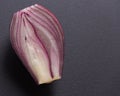 Half of a red onion on a black background