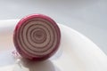 Half of red onion on white plate Royalty Free Stock Photo