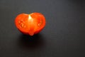 Half a red ripe heart shaped tomato on a black background Royalty Free Stock Photo