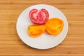 Pieces of red and yellow tomatoes on white dish