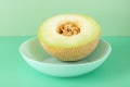 half ripe Galia melon with the seeds inside on a blue deep plate Royalty Free Stock Photo