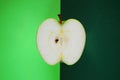 Half a ripe green apple on a green background Royalty Free Stock Photo