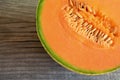 Half of ripe organic cantaloupe melon muskmelon, mushmelon, rockmelon on old wooden table. Royalty Free Stock Photo