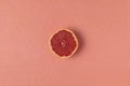 Half of ripe pink grapefruit on living coral background Royalty Free Stock Photo