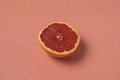 Half of ripe pink grapefruit on living coral background Royalty Free Stock Photo