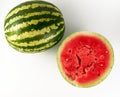 half ripe watermelon with red juicy pulp and seeds and a whole green Royalty Free Stock Photo