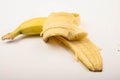 Half a ripe yellow partially peeled banana on a white background. Close up Royalty Free Stock Photo
