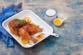 Half roasted chicken with lemon, on enameled baking dish