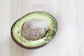 Half rotten avocado on wood background