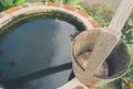 Half round brick water well with wooden bucket