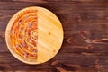 Half of salsiccia pizza with beef sausages, mozzarella, various sauces and marinated red onions on a round wooden platter Royalty Free Stock Photo