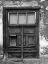 Half shuttered old shabby window in a decaying house Royalty Free Stock Photo