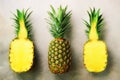 Half slice of fresh pineapple and whole fruit on gray background. Top View. Copy Space. Bright pineapples pattern for Royalty Free Stock Photo