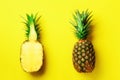 Half slice of fresh pineapple and whole fruit on yellow background. Top View. Copy Space. Bright pineapples pattern for Royalty Free Stock Photo