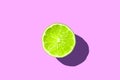 Half sliced green fresh lime with hard shadow on purple or pink background isolated. green lime summer concept Royalty Free Stock Photo