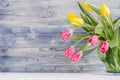 Half spring fresh tulips yellow and red bouquet on rustic shabby blue wooden background with copy space. Royalty Free Stock Photo