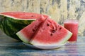 Half sweet watermelon, smoothie in a glass and sliced watermelon on a white plate on a blue background Royalty Free Stock Photo